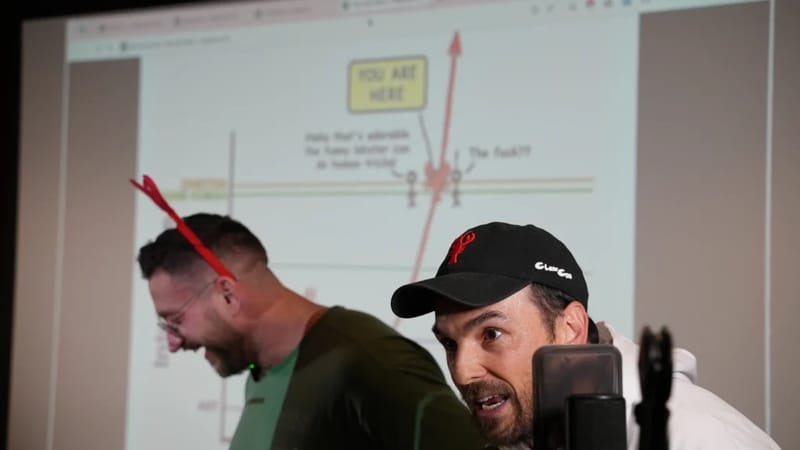 Michael Galpert wearing a ClawCon cap and Peter Steinberger co-presenting at ClawCon, with a YOU ARE HERE growth chart projected on the screen behind them