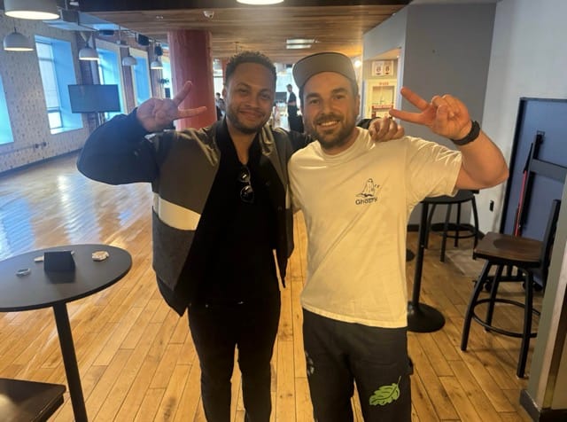 Michael Galpert and Tommye posing with peace signs at the ClawCon event venue
